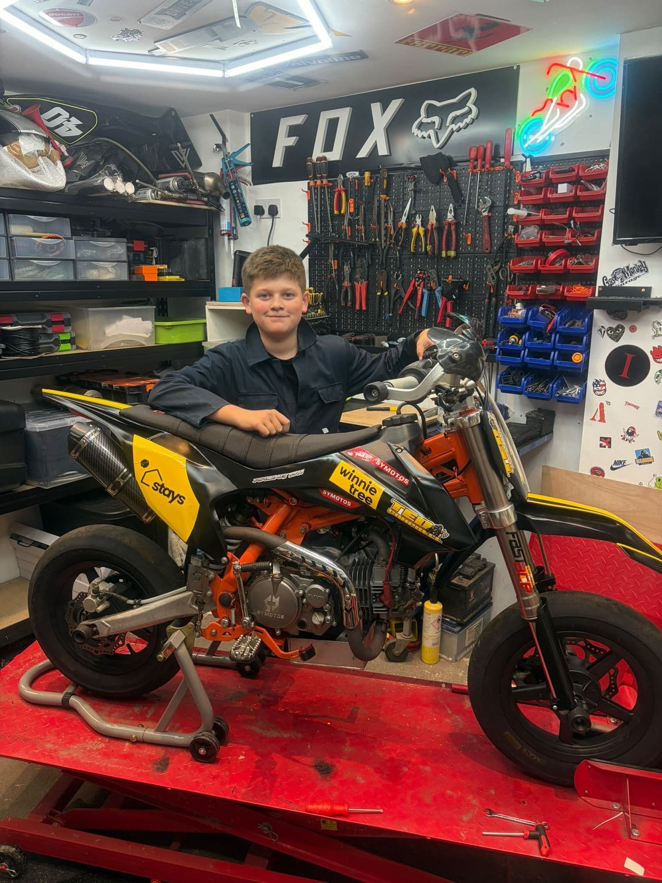 Ted in the workshop with a pit bike on the lift